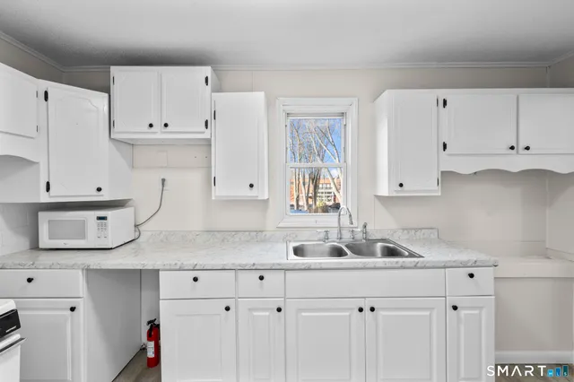 a kitchen with white cabinets and a sink
