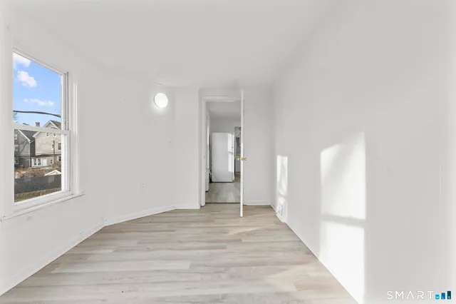 a view of a hallway with wooden floor and a large window