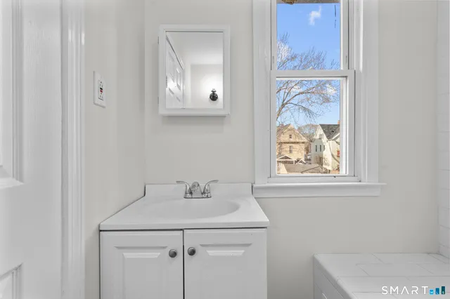 a bathroom with a sink a vanity and a window