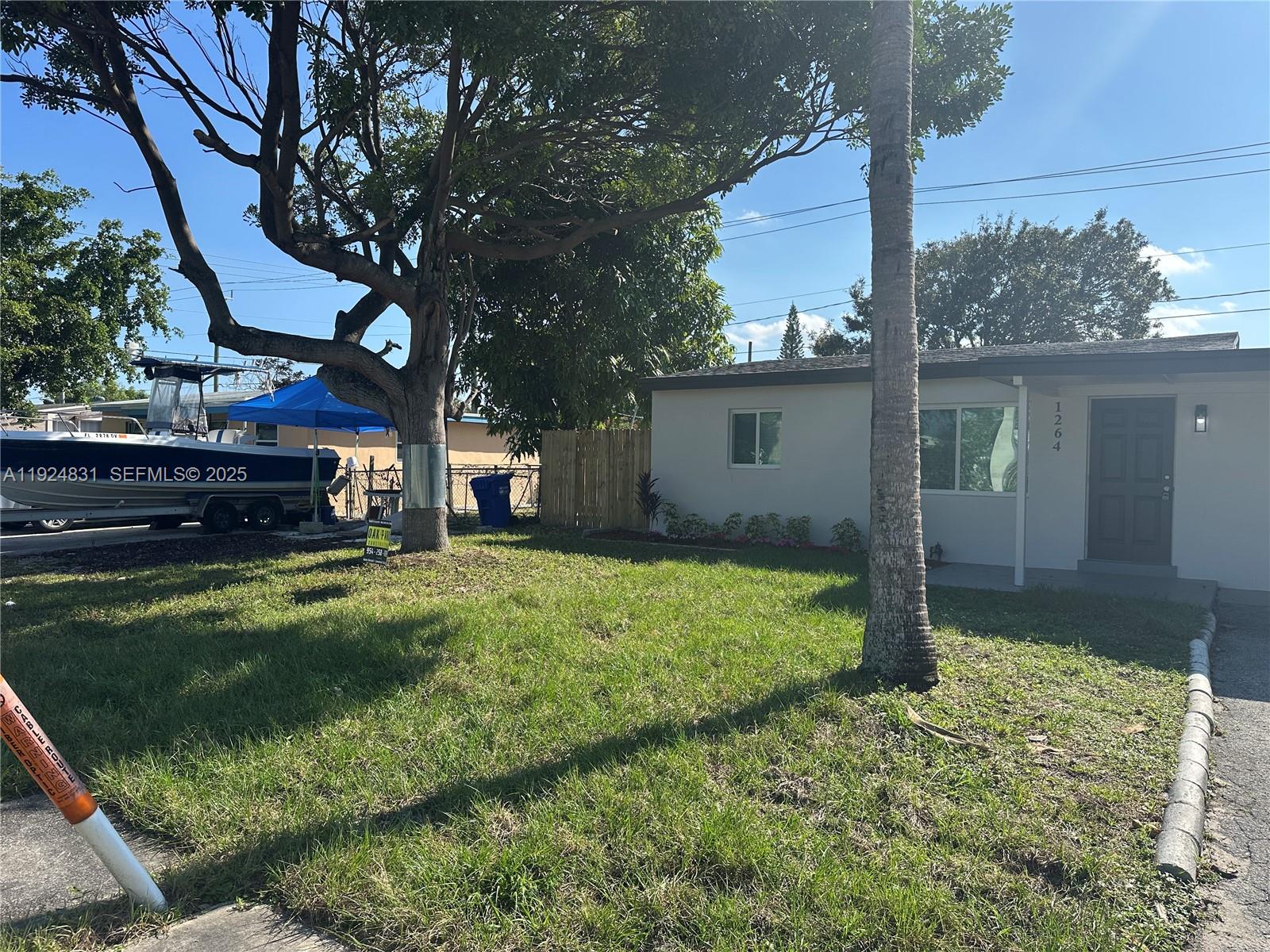 1264 Northeast 25th Court Pompano Beach, FL 33064 - Photo 2 of 19 a backyard of a house with a garden and plants