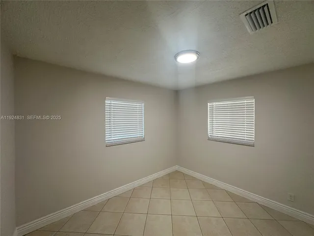 an empty room with windows and closet