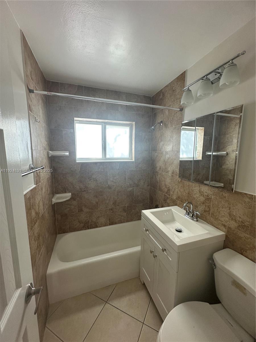 1264 Northeast 25th Court Pompano Beach, FL 33064 - Photo 10 of 19 a bathroom with a sink a toilet and bathtub