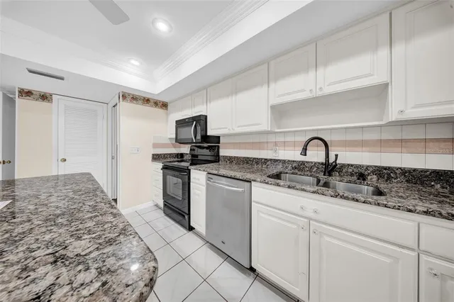 a kitchen with white cabinets and appliances