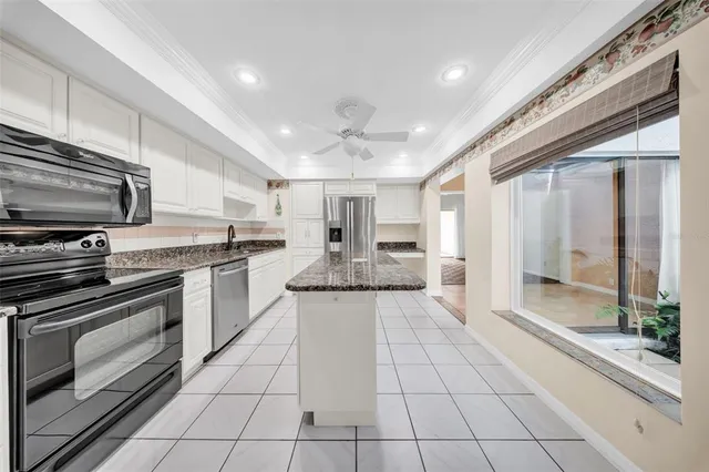 a large kitchen with stainless steel appliances granite countertop a stove and a sink
