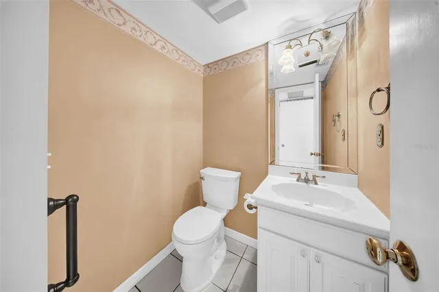 a bathroom with a toilet sink vanity and mirror