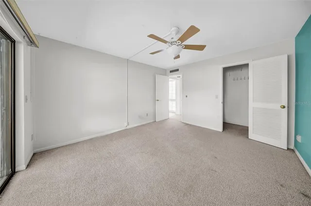 a view of a livingroom with a ceiling fan & window