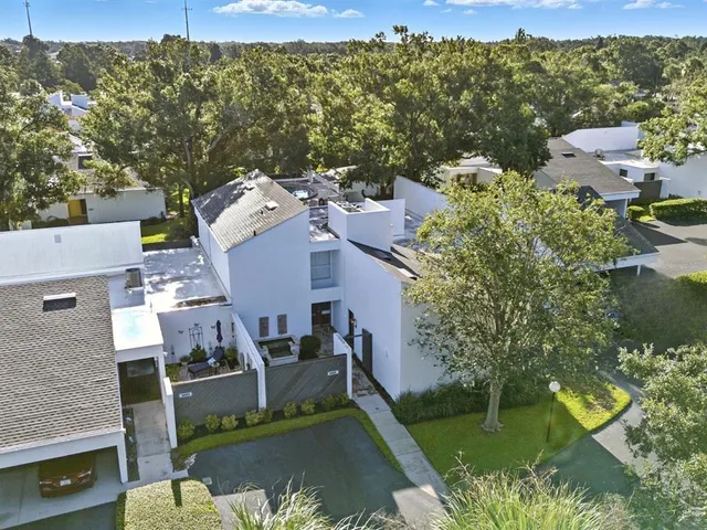 an aerial view of a house with a garden and lake view