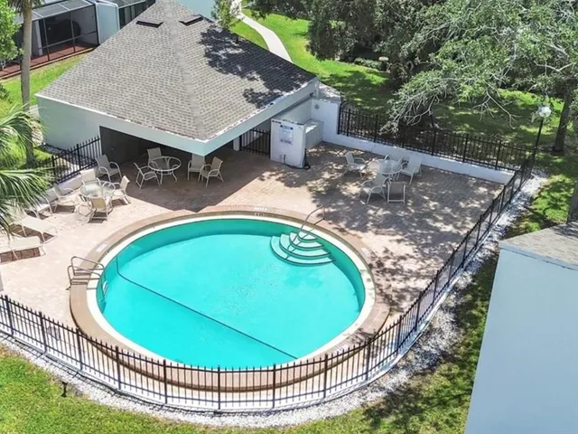 an aerial view of a house with swimming pool and outdoor seating