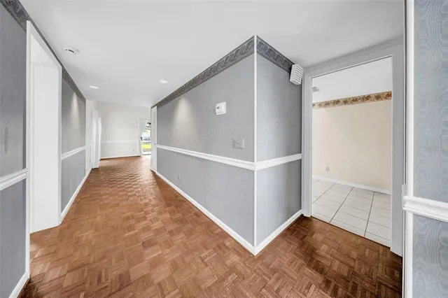 a view of a hallway with wooden floor and closet