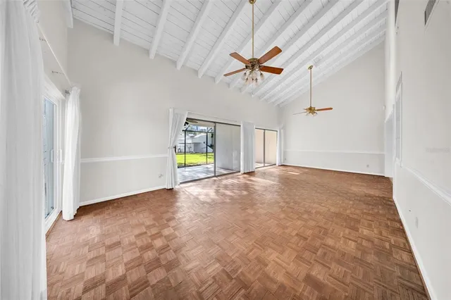 an empty room with ceiling fan and window