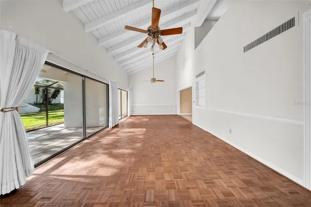 a view of empty room with wooden floor and fan