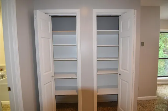 a view of walk in closet with empty racks