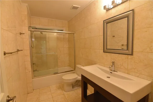 a bathroom with a sink mirror toilet and shower