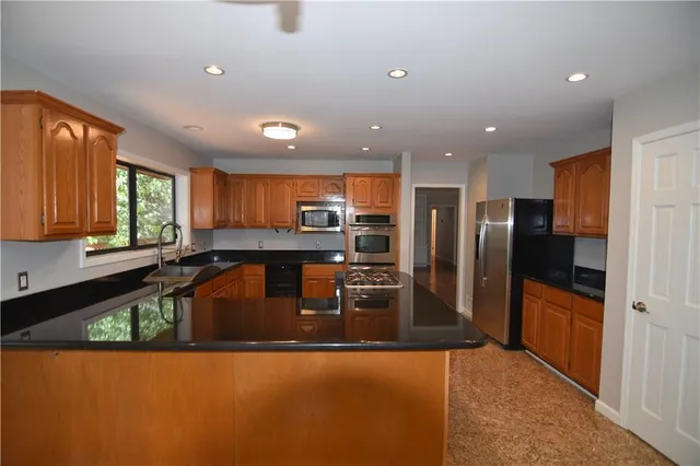 a large kitchen with stainless steel appliances a large counter top
