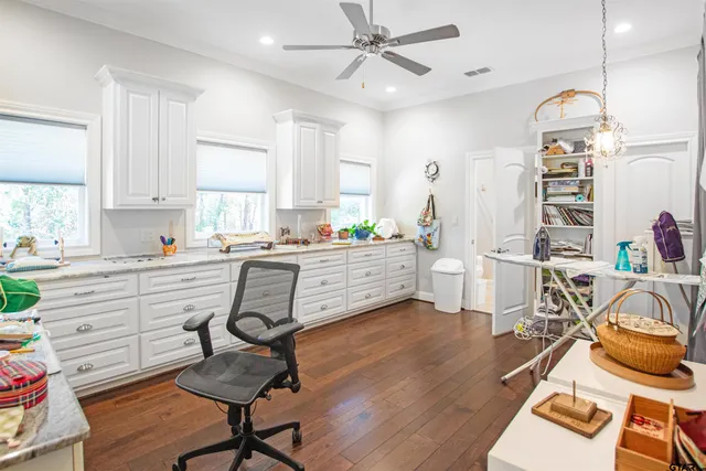 a kitchen with stainless steel appliances a dining table chairs stove and white cabinets