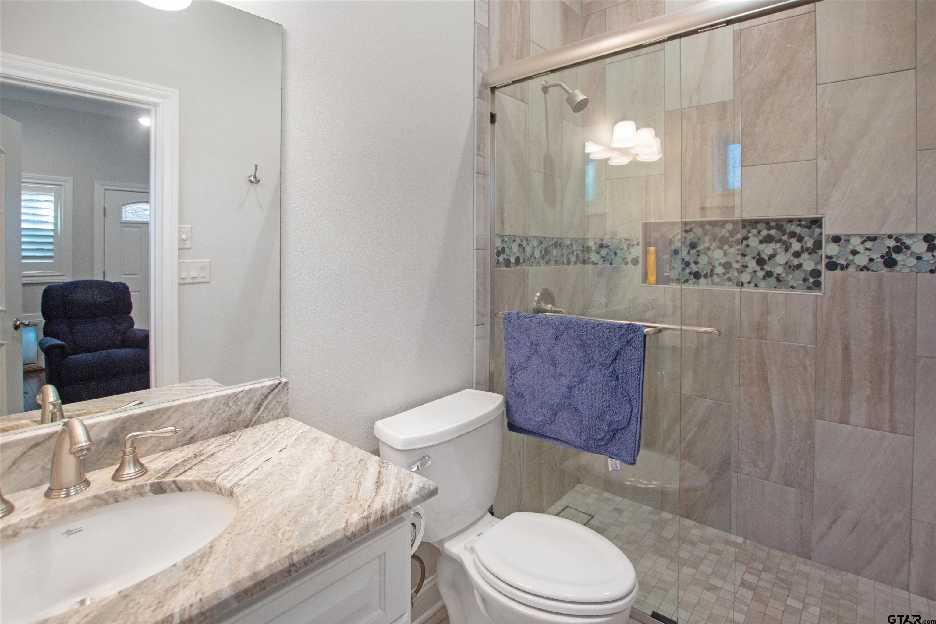 15722 Timberhill Drive Flint, TX 75762 - Photo 16 of 48 a bathroom with a granite countertop toilet sink and mirror