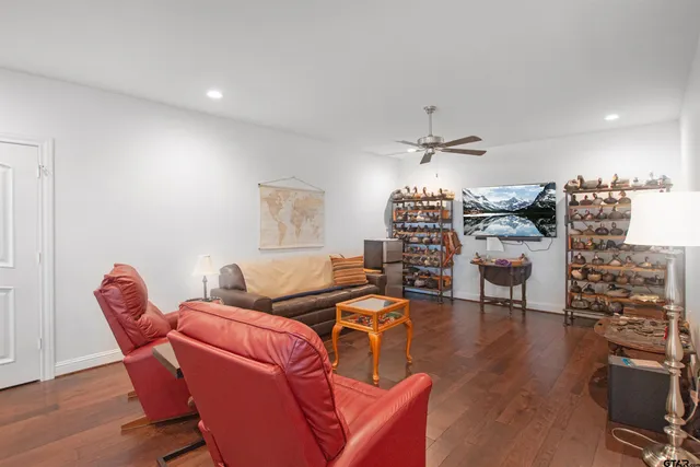 a living room with furniture a chandelier and a wooden floor