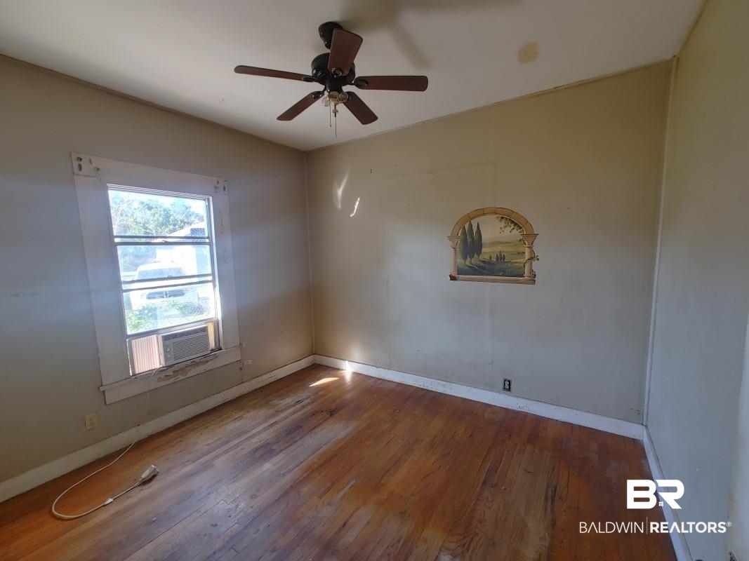 1706 Lomeroy Street Mobile, AL 36604 - Photo 10 of 24 Spare room with cooling unit, ceiling fan, baseboards, and wood finished floors