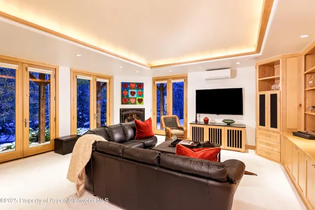 a large living room with stainless steel appliances kitchen island granite countertop a couch and a large window