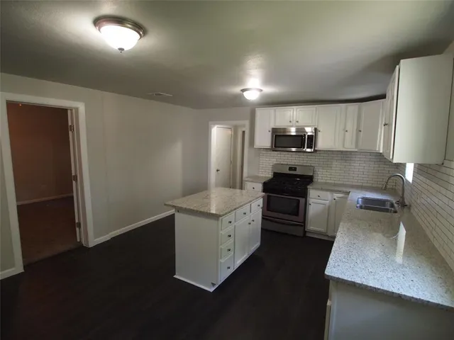 a kitchen with cabinets microwave and refrigerator