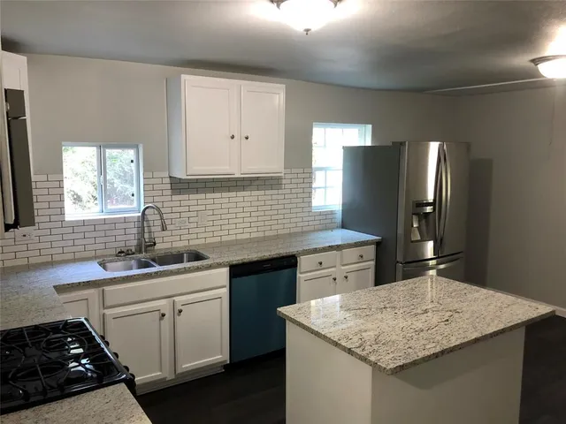 a kitchen with a sink stove and cabinets