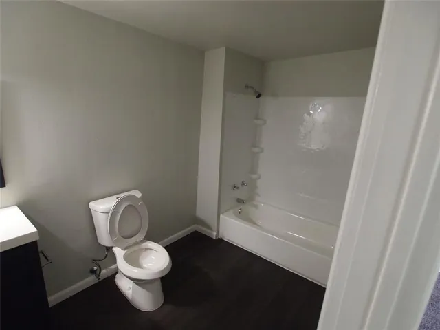 a white toilet sitting next to a bath tub