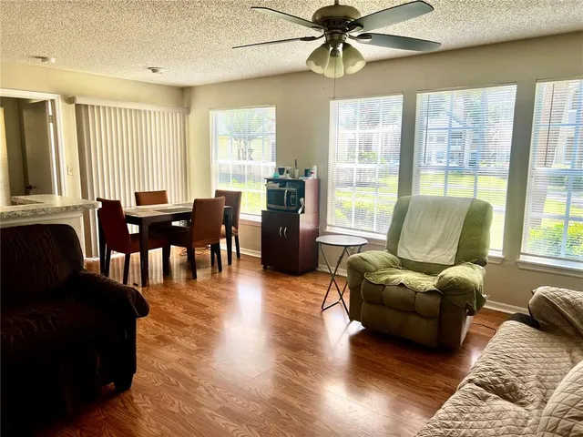 a living room with furniture kitchen view and a window