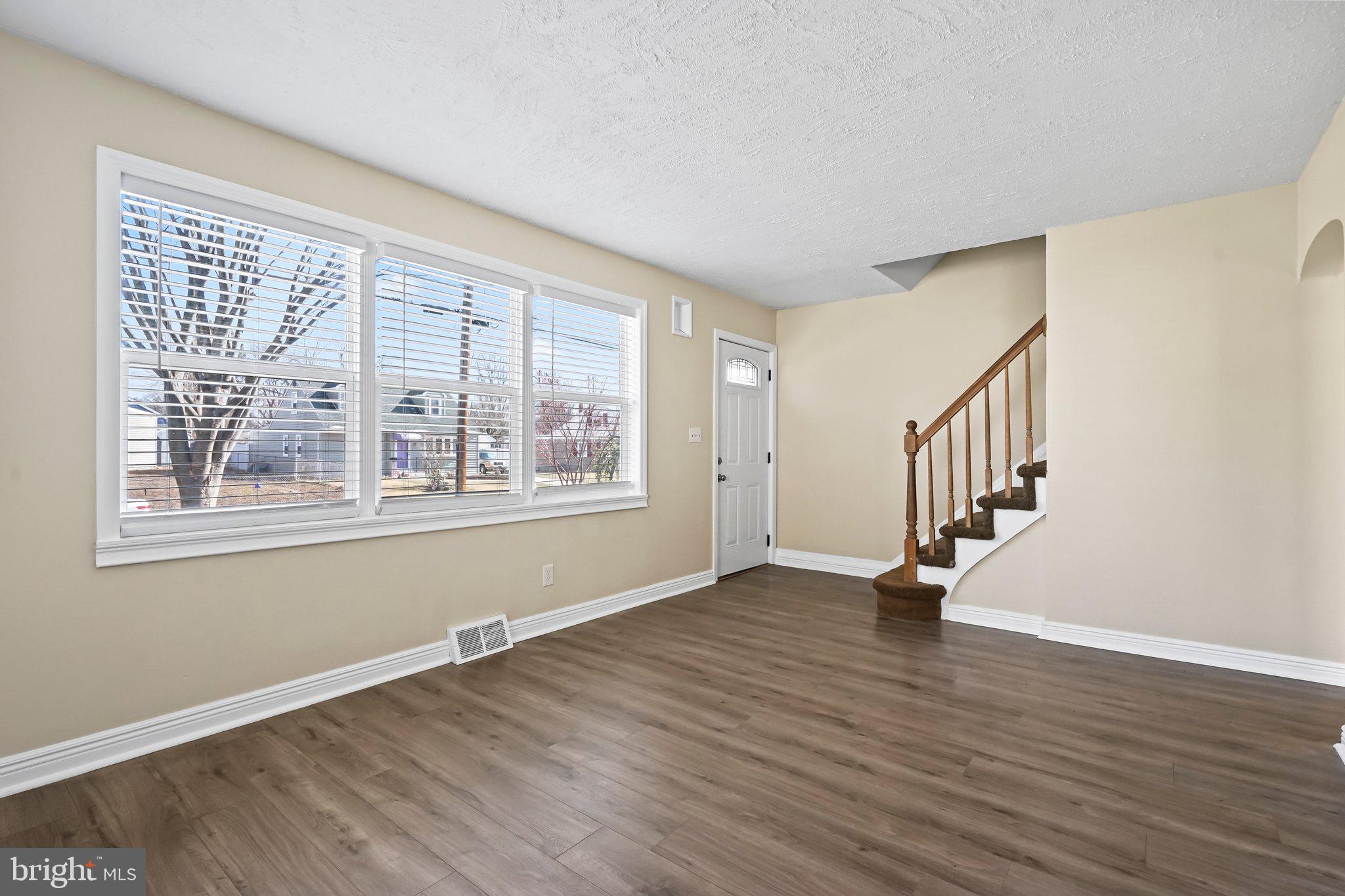 312 Wynnewood Road Ewing, NJ 08628 - Photo 3 of 24 a view of an empty room with wooden floor and a window