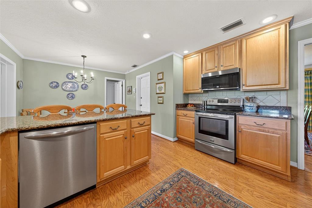 1053 Sweetbriar Road Orlando, FL 32806 - Photo 35 of 79 a kitchen with stainless steel appliances granite countertop a stove a sink and a refrigerator