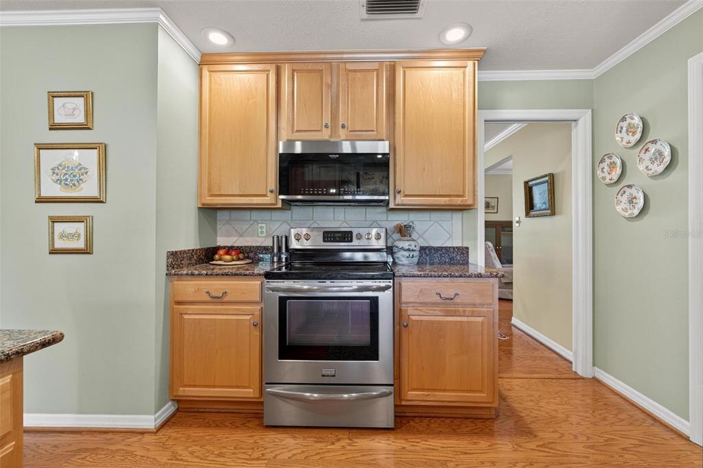 1053 Sweetbriar Road Orlando, FL 32806 - Photo 36 of 79 a kitchen with stainless steel appliances granite countertop a stove a refrigerator and a microwave