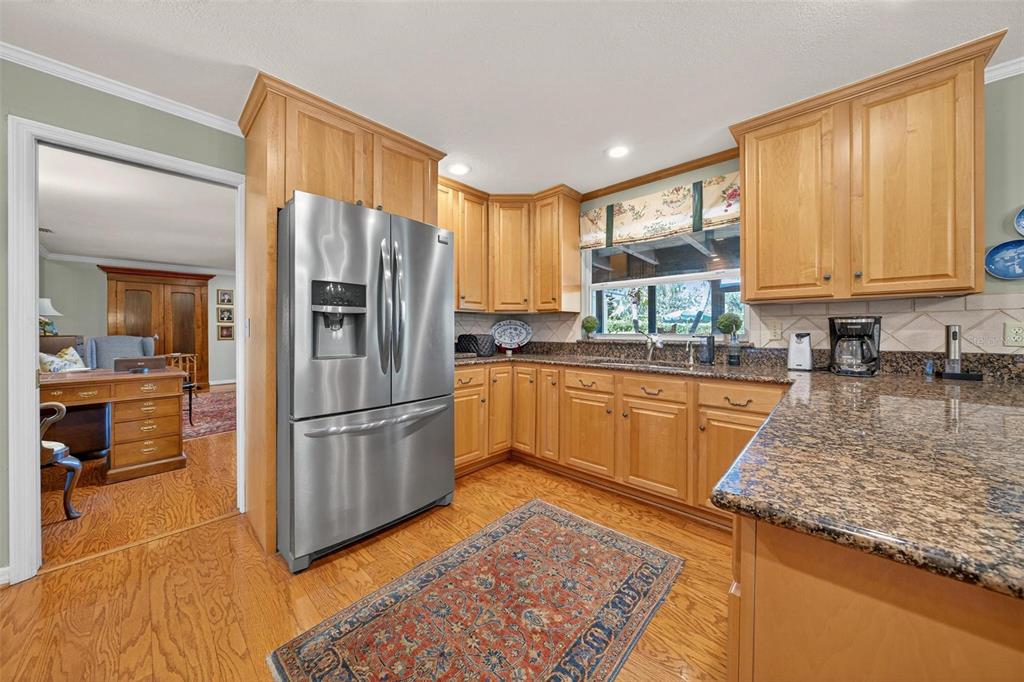 1053 Sweetbriar Road Orlando, FL 32806 - Photo 37 of 79 a kitchen with stainless steel appliances granite countertop a refrigerator sink and cabinets