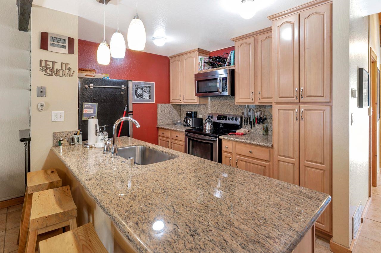 1001 Commonwealth Drive, Unit 156 Kings Beach, CA 96143 - Photo 4 of 21 a kitchen with stainless steel appliances granite countertop a sink refrigerator and cabinets
