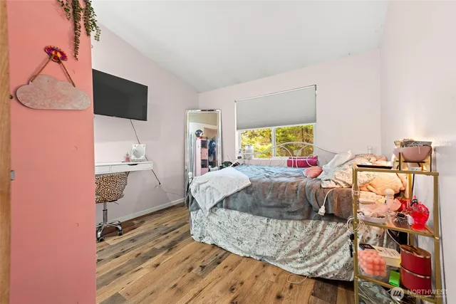 a living room with a bed furniture and a flat screen tv