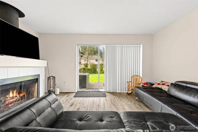 a living room with furniture a flat screen tv and a fireplace