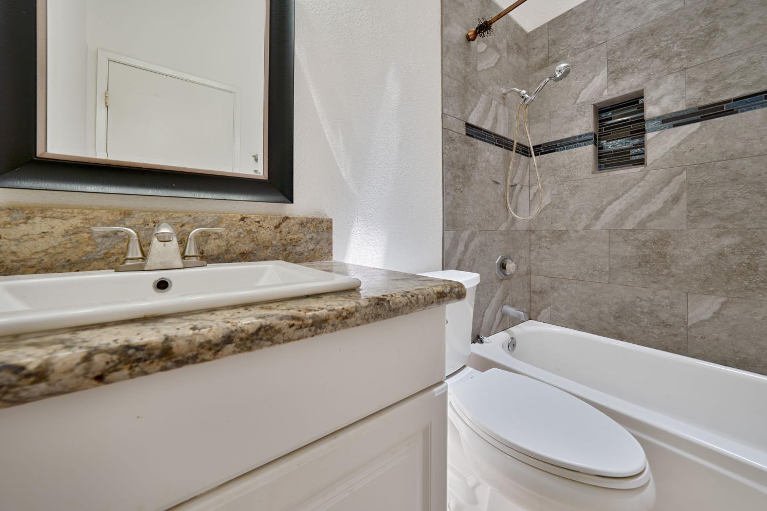 9237 Madison Avenue Orangevale, CA 95662 - Photo 19 of 40 a bathroom with a granite countertop sink toilet and mirror