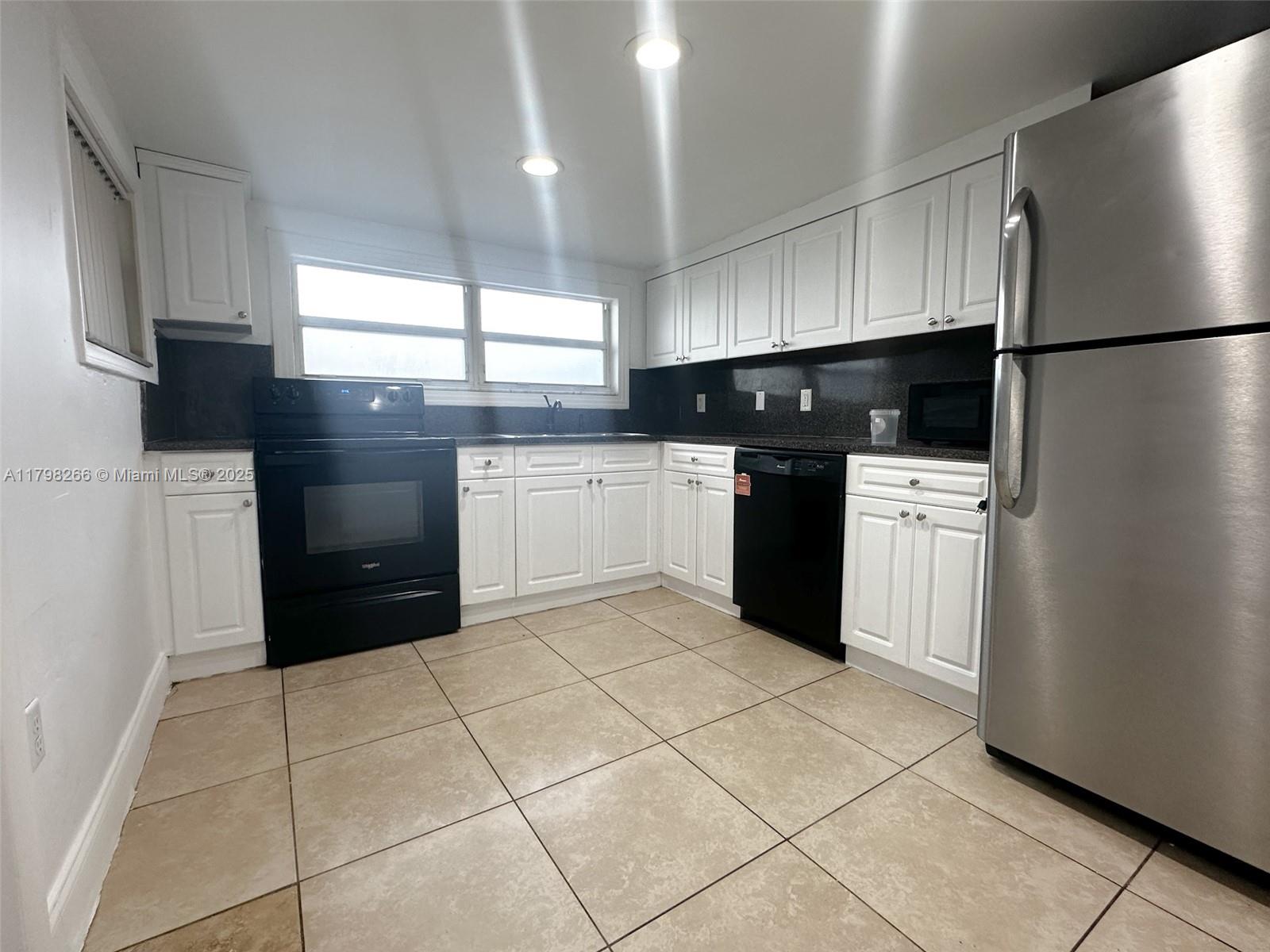 2811 Northwest 88th Street, Unit 1 Miami, FL 33147 - Photo 6 of 10 a kitchen with a refrigerator and a stove