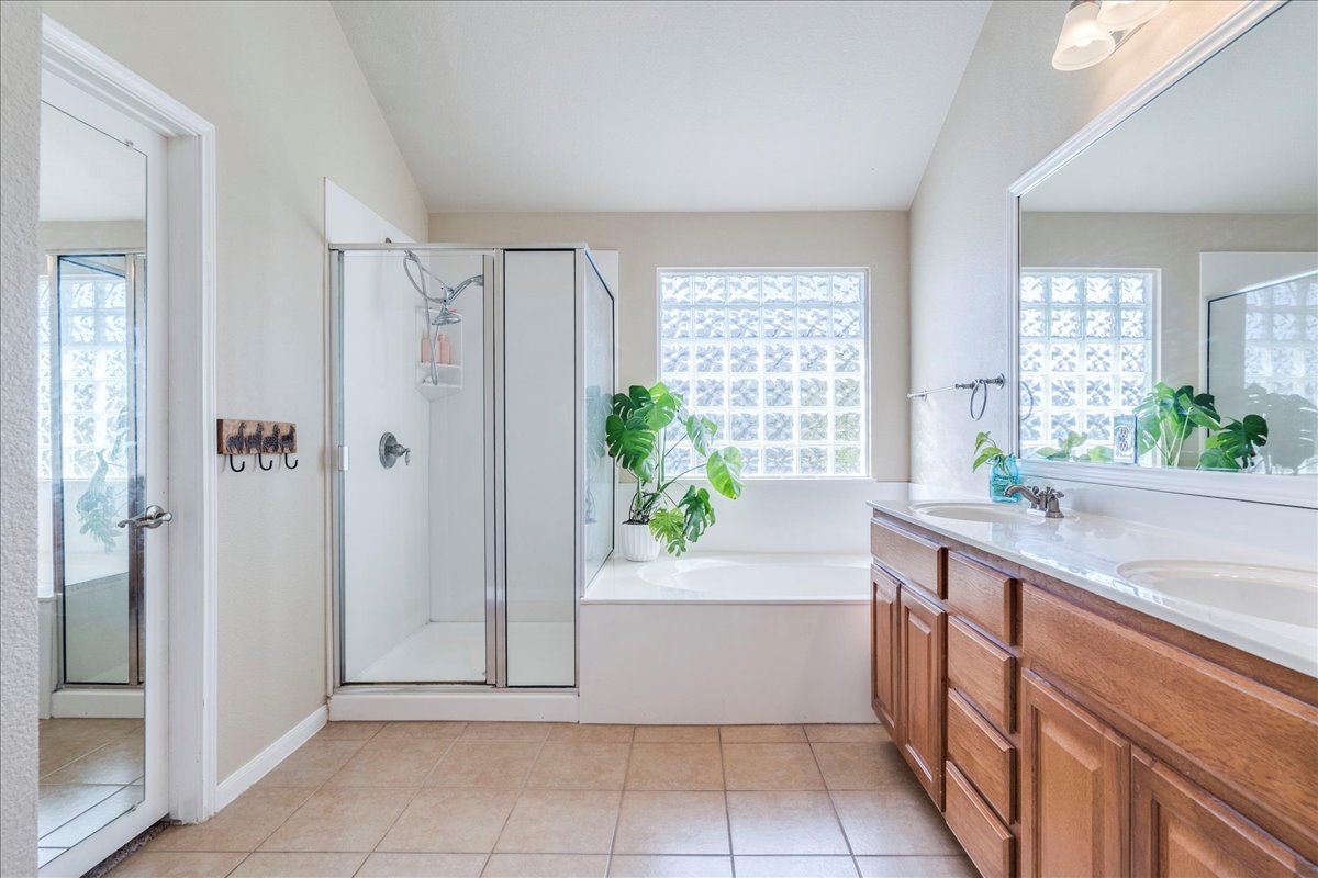 18424 Dry Brook Loop Pflugerville, TX 78660 - Photo 18 of 25 Bathroom with a shower stall, a garden tub, double vanity, and healthy amount of natural light
