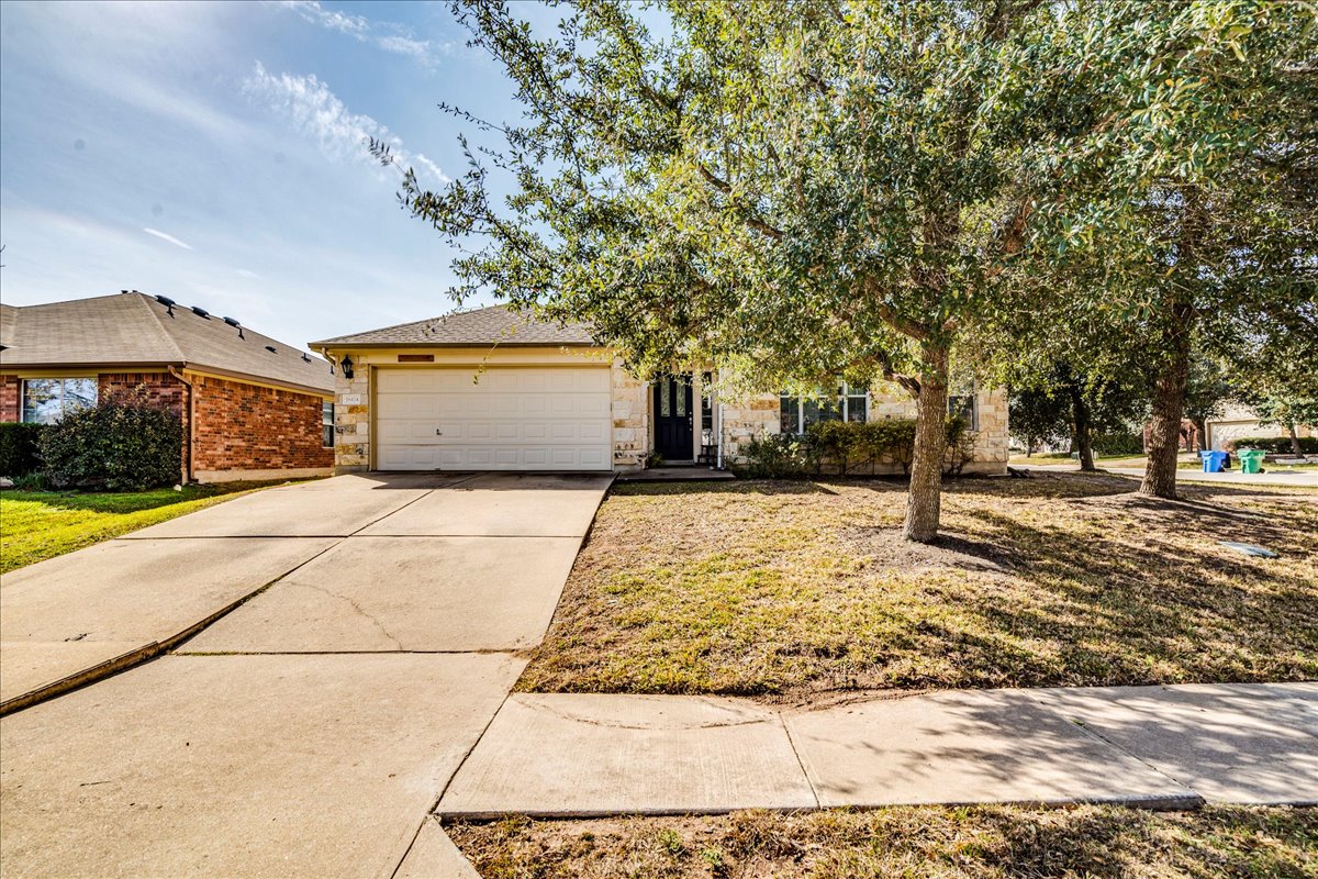 18424 Dry Brook Loop Pflugerville, TX 78660 - Photo 2 of 25 View of front of property with concrete driveway, an attached garage, and brick siding