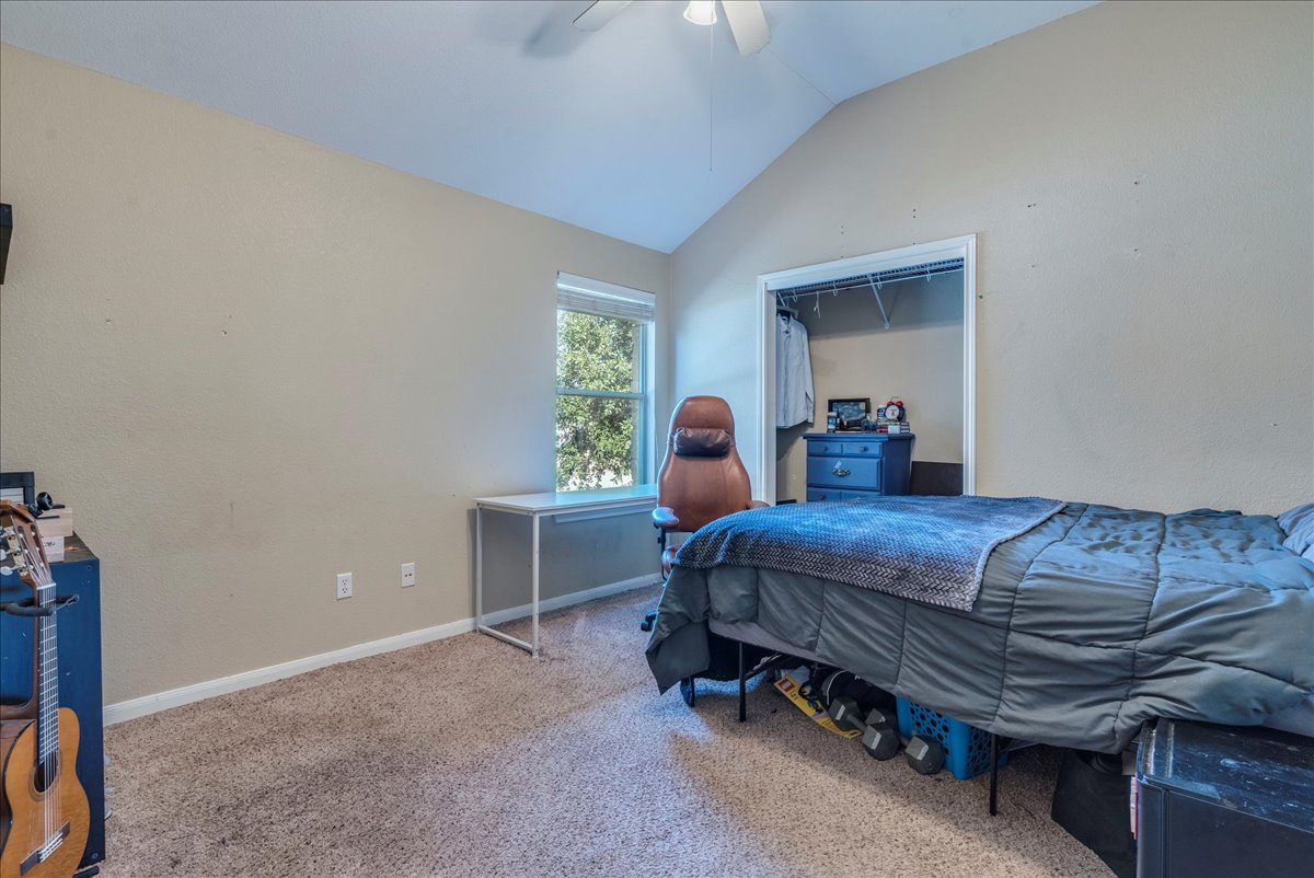 18424 Dry Brook Loop Pflugerville, TX 78660 - Photo 21 of 25 Carpeted bedroom with vaulted ceiling and ceiling fan