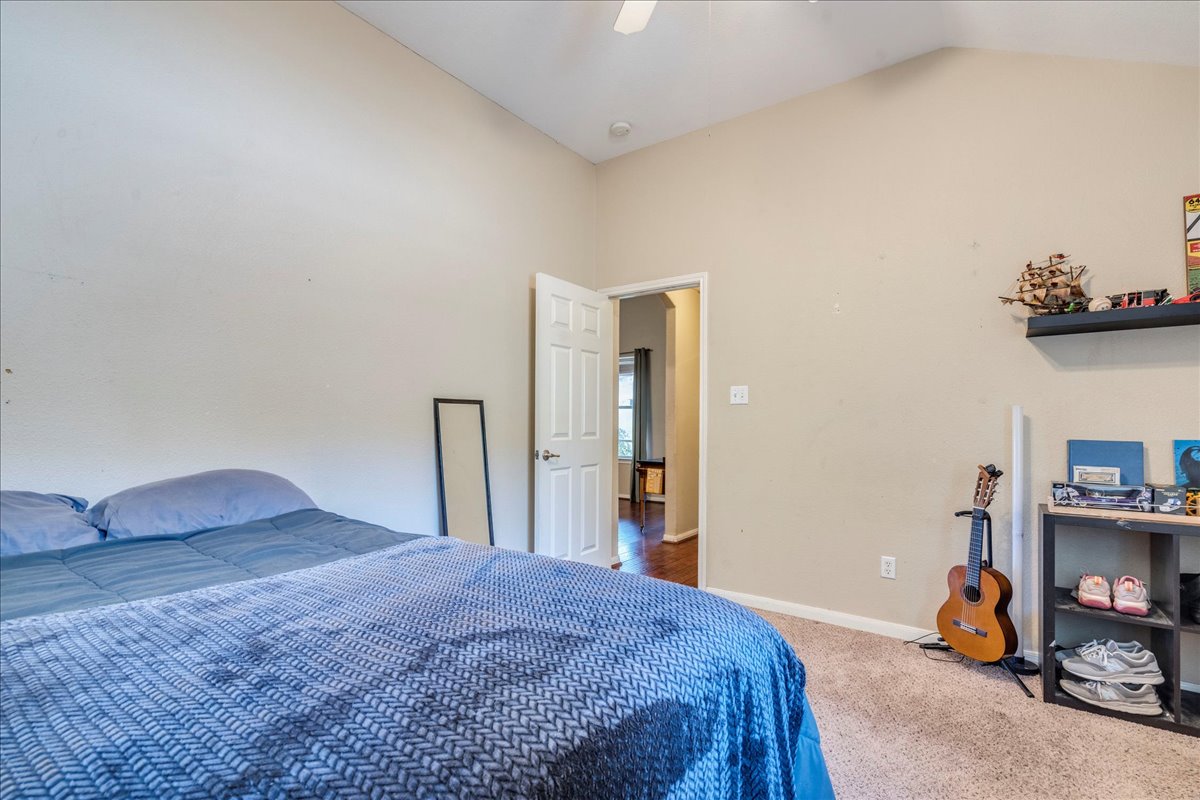 18424 Dry Brook Loop Pflugerville, TX 78660 - Photo 22 of 25 Bedroom featuring carpet floors, vaulted ceiling, and ceiling fan