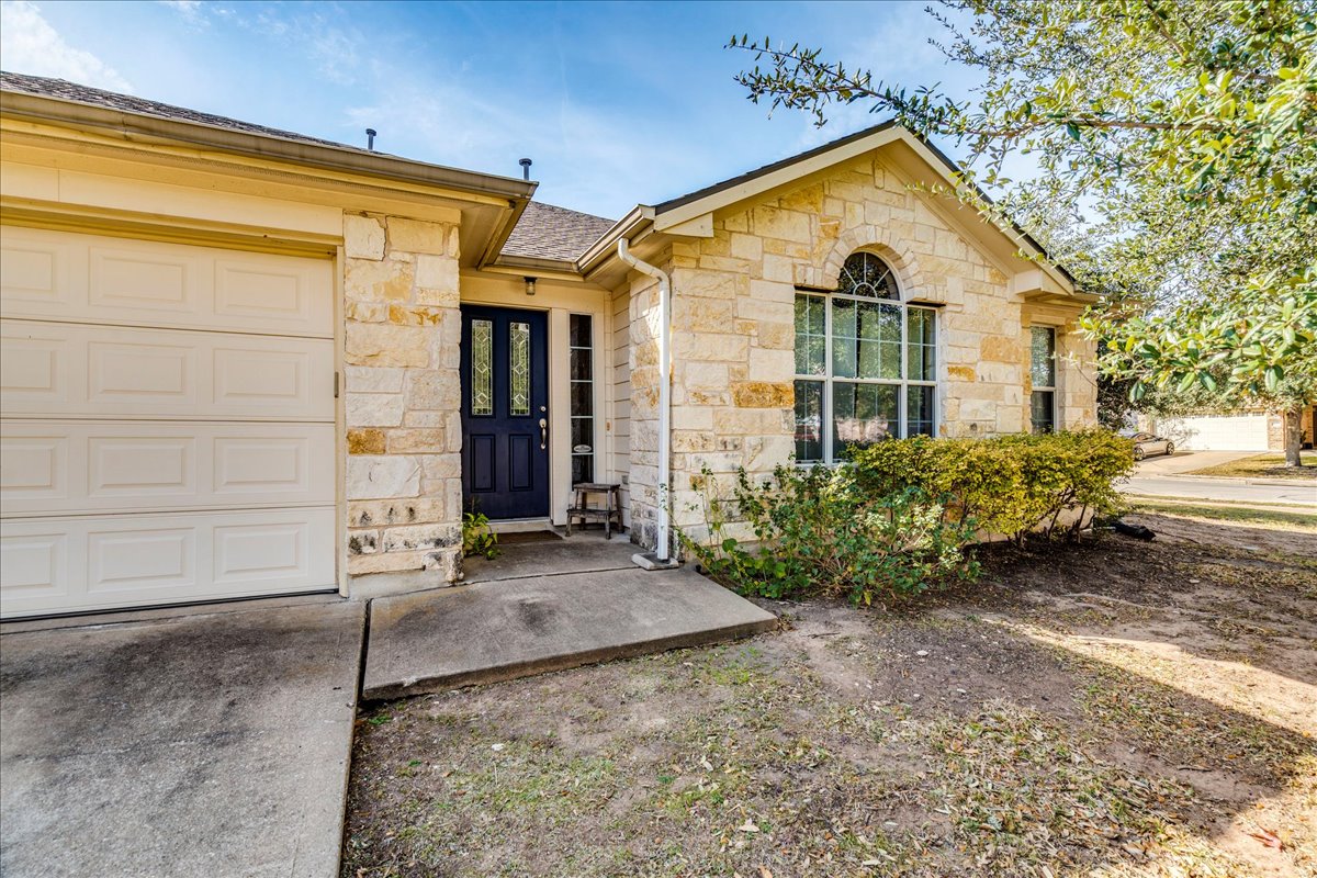 18424 Dry Brook Loop Pflugerville, TX 78660 - Photo 6 of 25 Doorway to property with stone siding and an attached garage