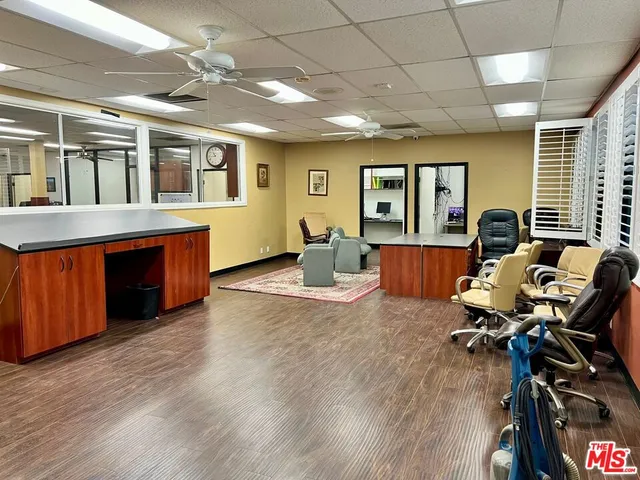 a living room with furniture large window and wooden floor
