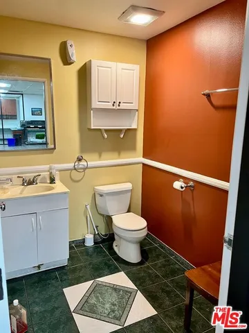 a bathroom with a toilet a sink and mirror