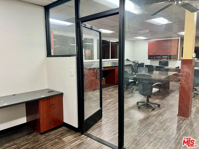 a view of a hallway with a computer on a desk and chair