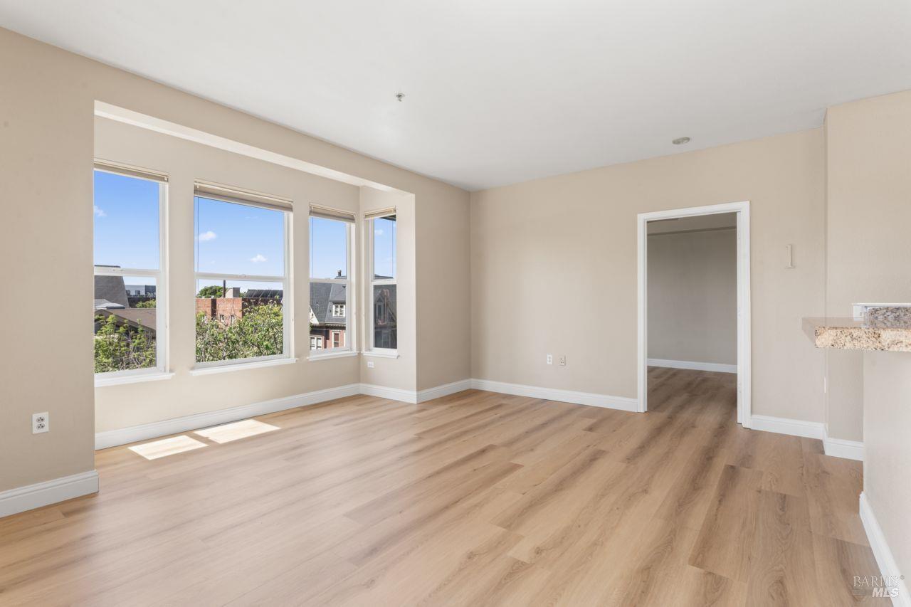 655 12th Street, Unit 311 Oakland, CA 94607 - Photo 2 of 29 a view of an empty room with wooden floor and a window