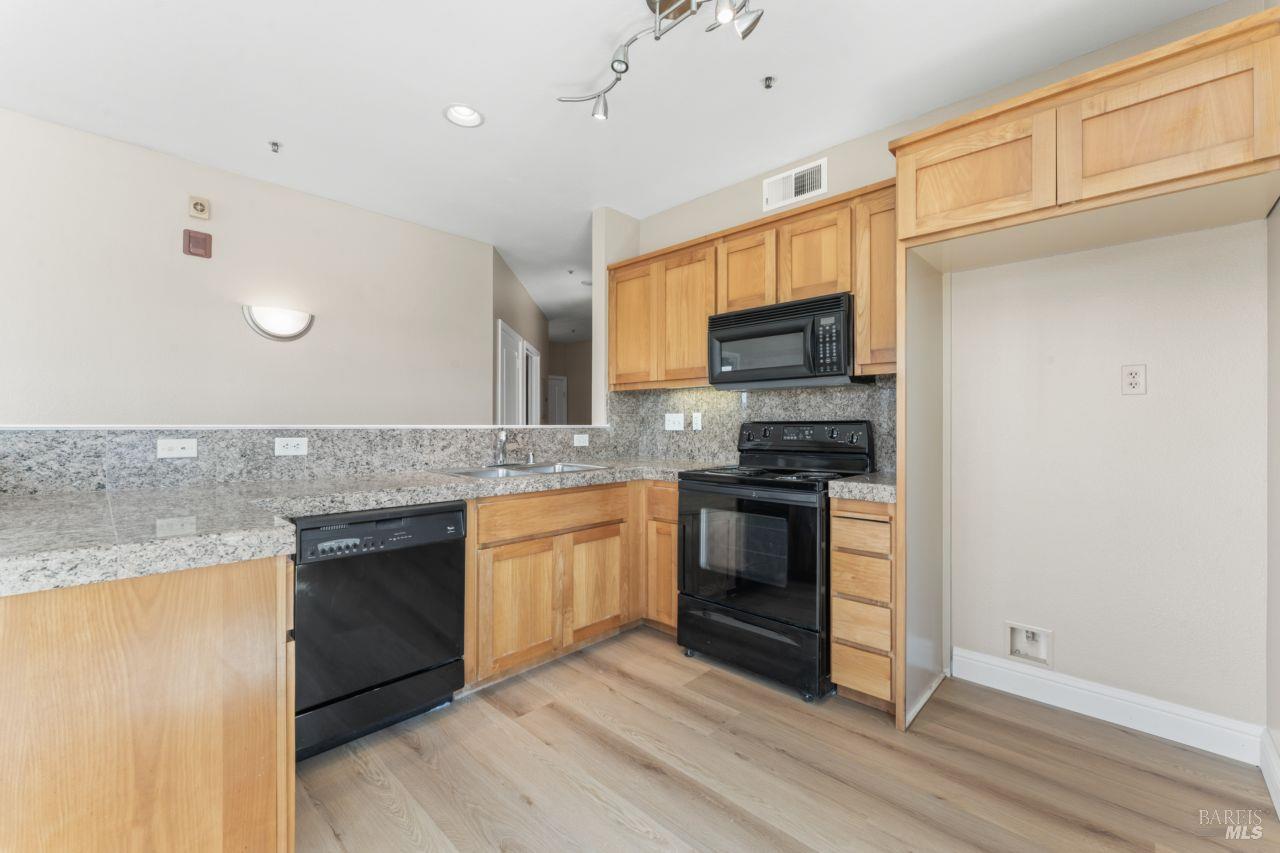 655 12th Street, Unit 311 Oakland, CA 94607 - Photo 24 of 29 a kitchen with granite countertop a stove top oven and sink