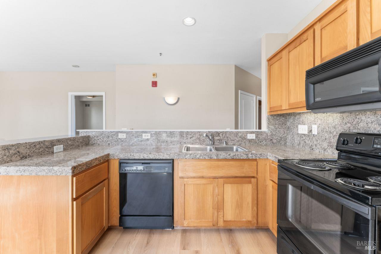 655 12th Street, Unit 311 Oakland, CA 94607 - Photo 9 of 29 a kitchen with stainless steel appliances granite countertop a stove and a sink