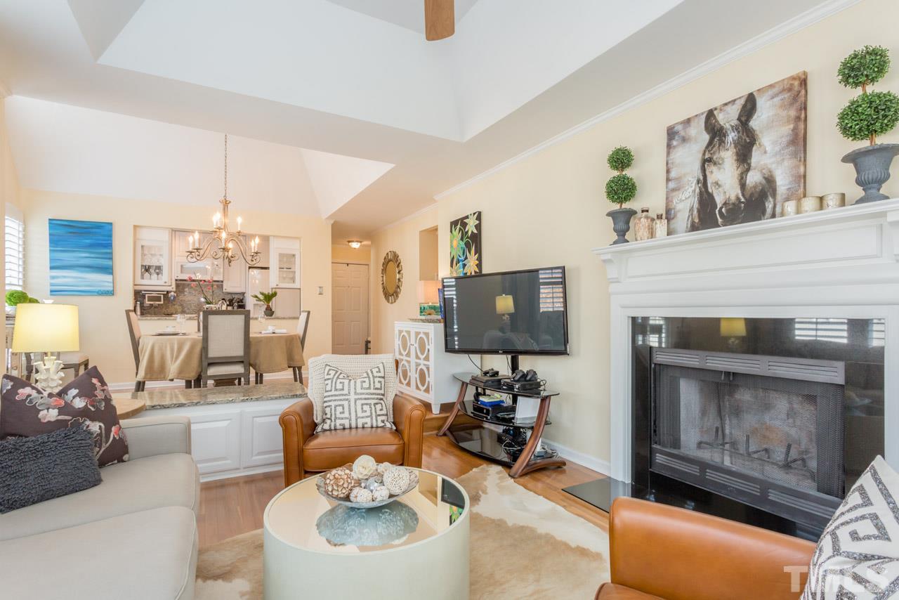 1000 Brighthurst Drive, Unit 301 Raleigh, NC 27605 - Photo 12 of 24 a living room with furniture a fireplace and a flat screen tv