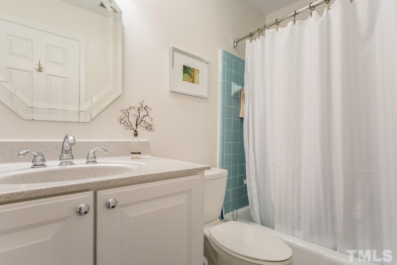 1000 Brighthurst Drive, Unit 301 Raleigh, NC 27605 - Photo 14 of 24 a bathroom with a sink a toilet and shower curtain