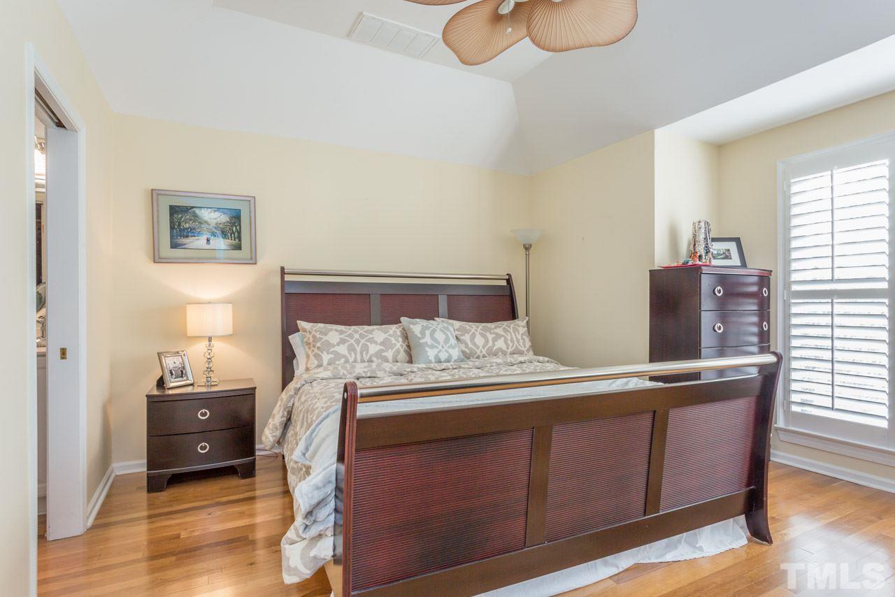 1000 Brighthurst Drive, Unit 301 Raleigh, NC 27605 - Photo 15 of 24 a bedroom with a bed and wooden floor
